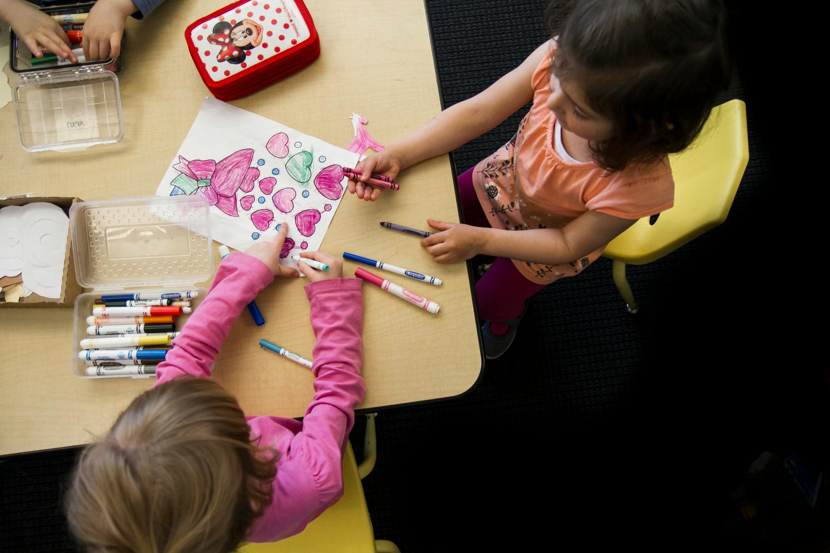 Two children drawing at a table