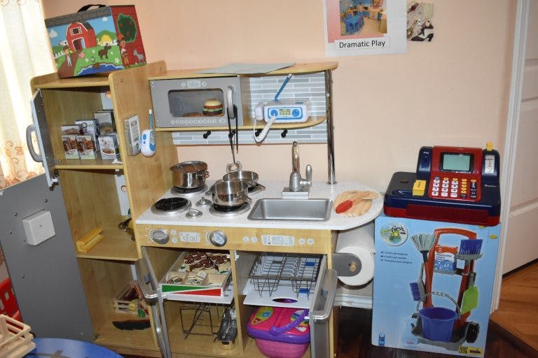 Toy kitchen set with a refrigerator, stove, sink, and microwave