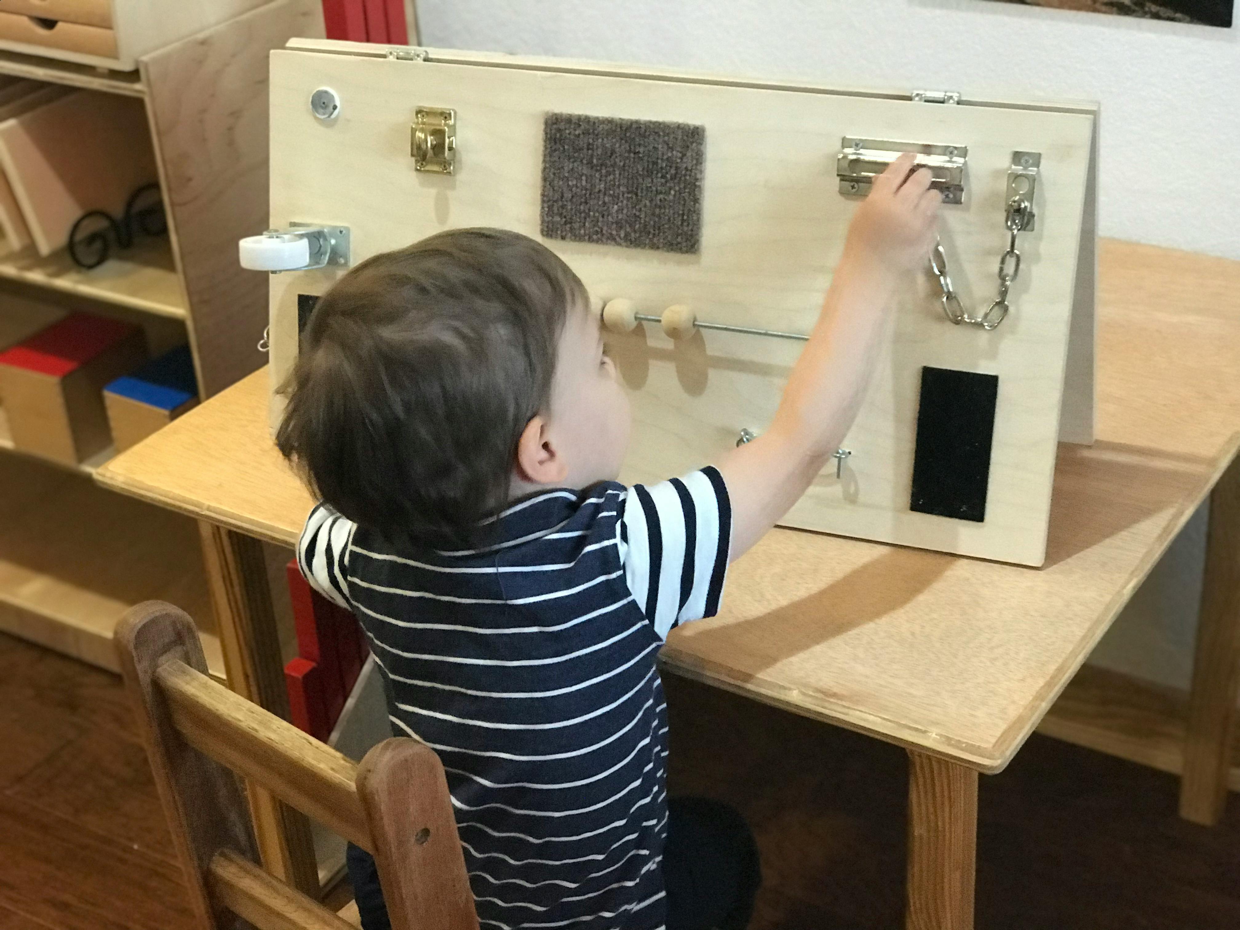 Child playing with a wooden activity board