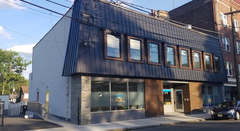 Two-story building with dark siding and large windows