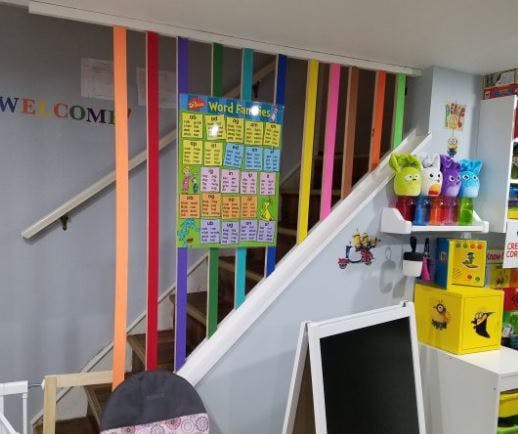 Staircase decorated with colorful streamers and a learning chart