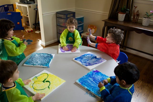 Children painting at a round table