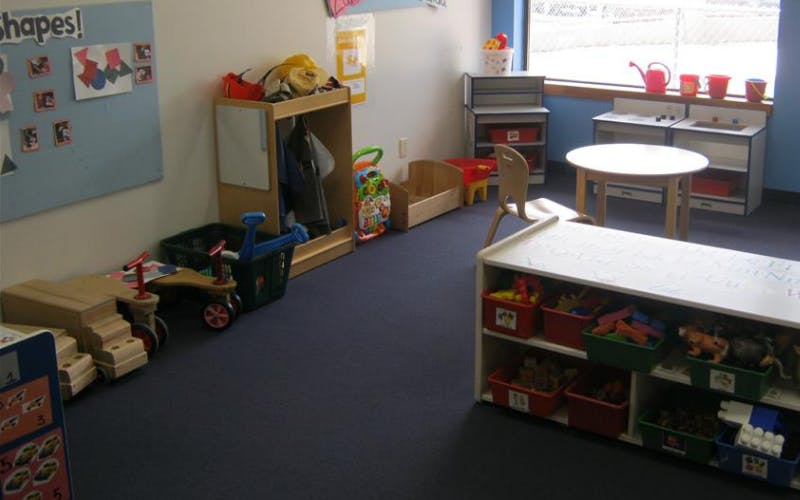 A playroom with child-sized furniture and shelves full of toys