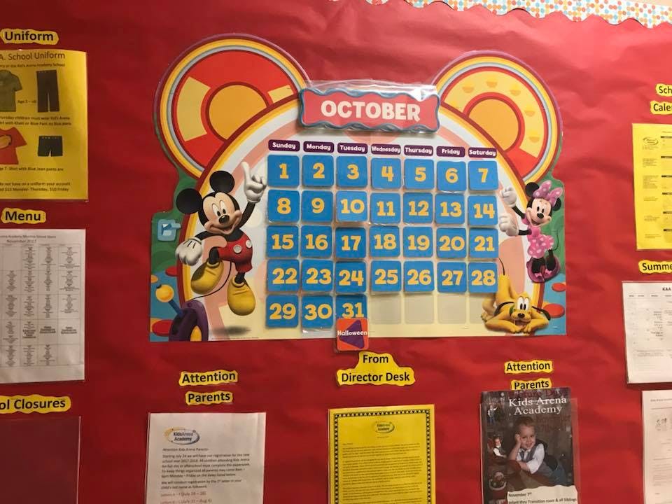 Mickey Mouse themed October calendar on a red bulletin board