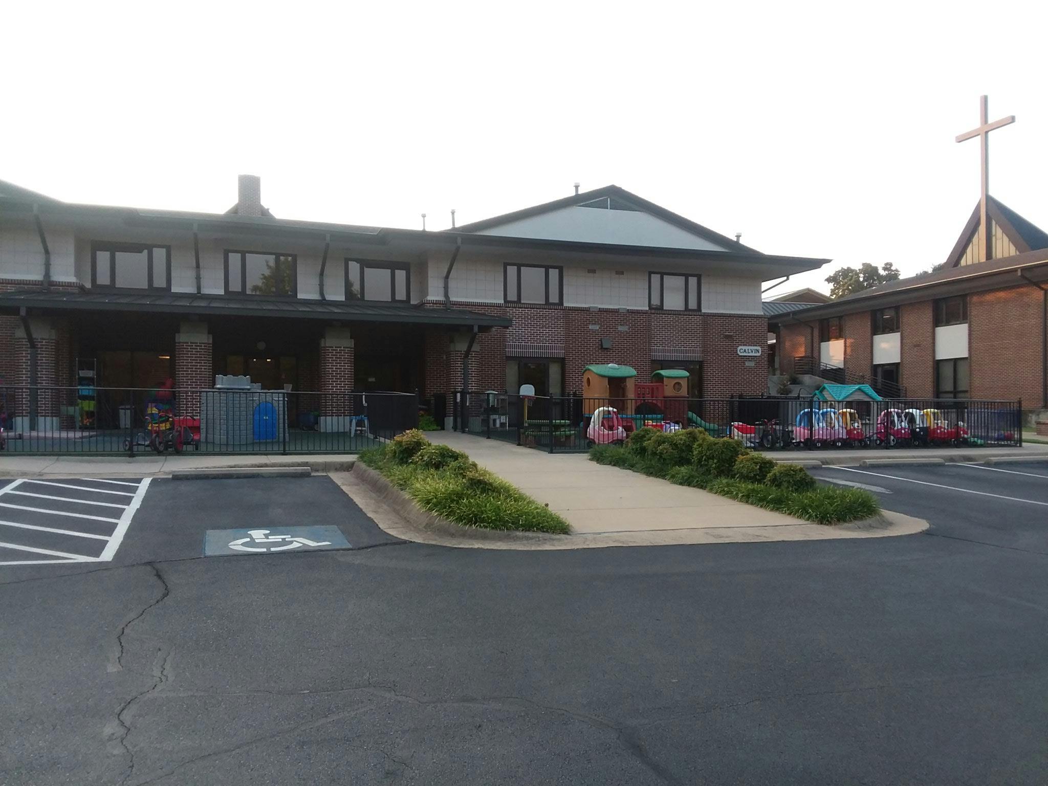 Building with a cross on the roof and a playground area outside