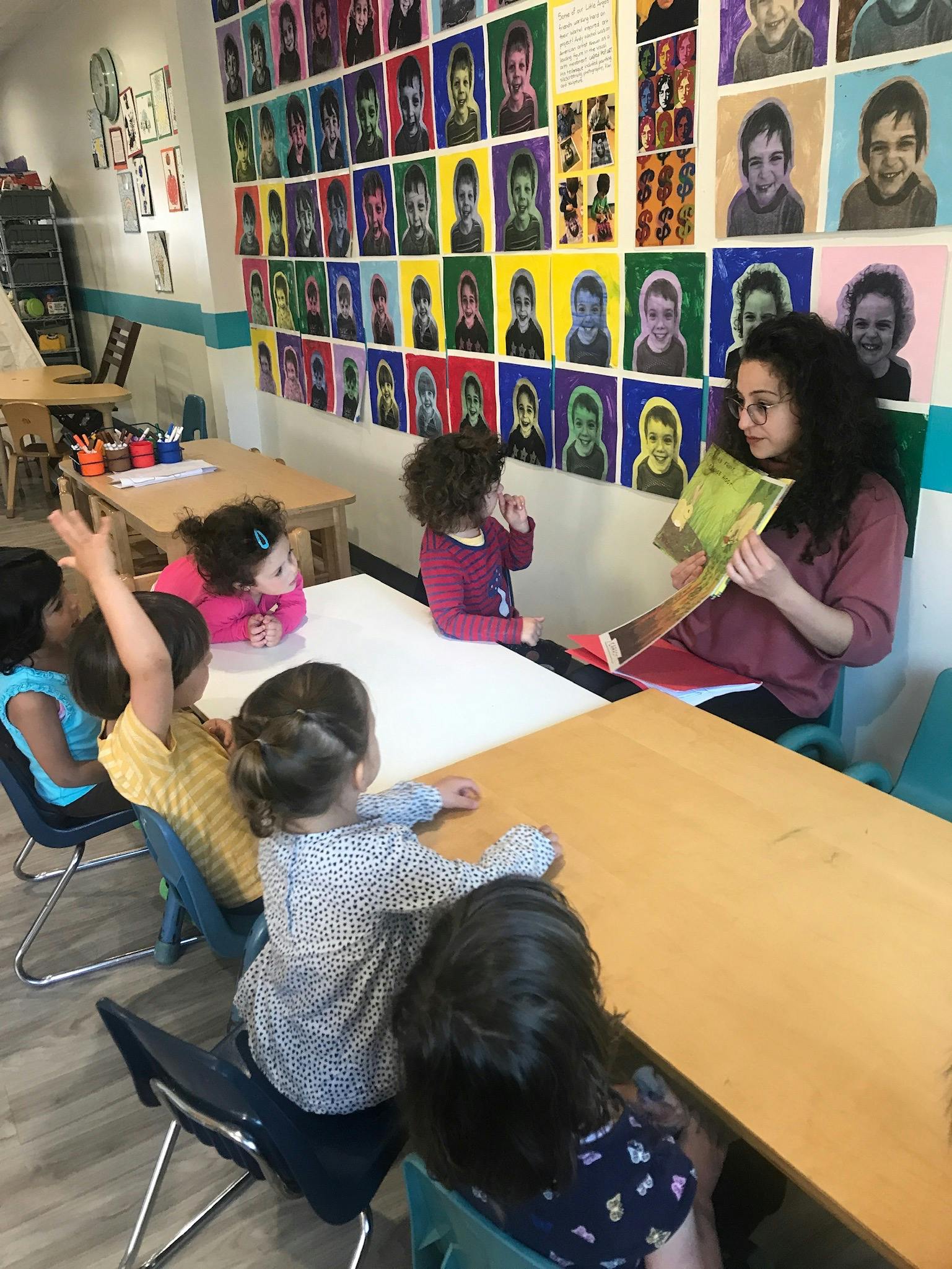 Adult reading a book to children in a classroom