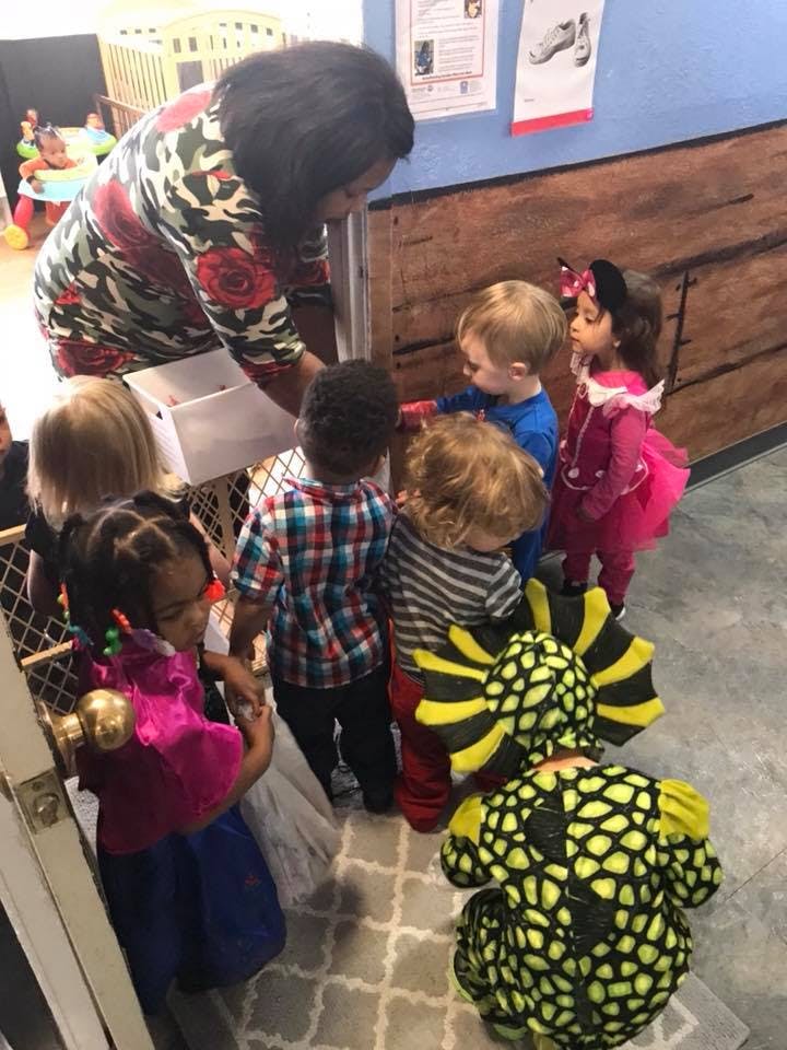 Adult and several children gathered around a box