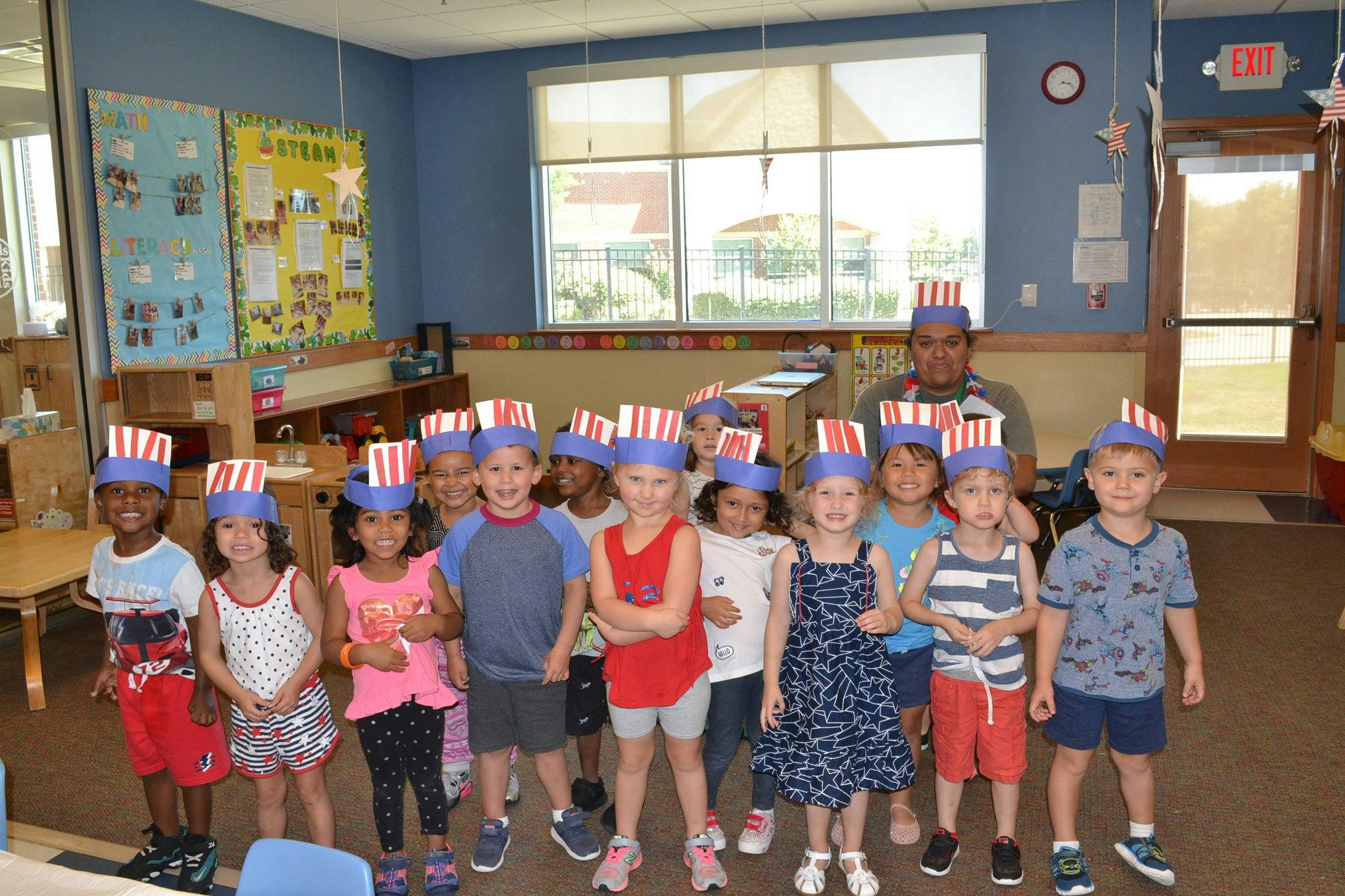 Group of children and one adult wearing red, white, and blue hats