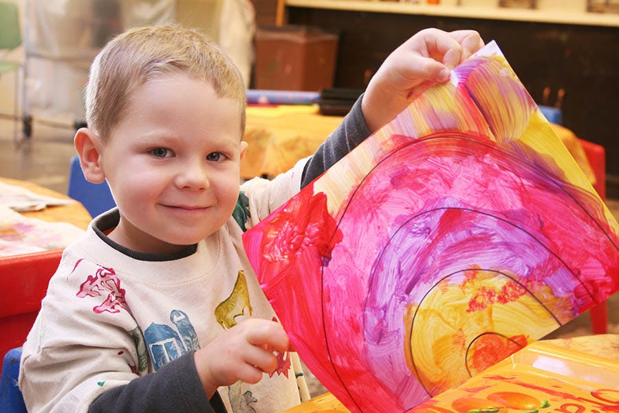 Child holding up a colorful painting