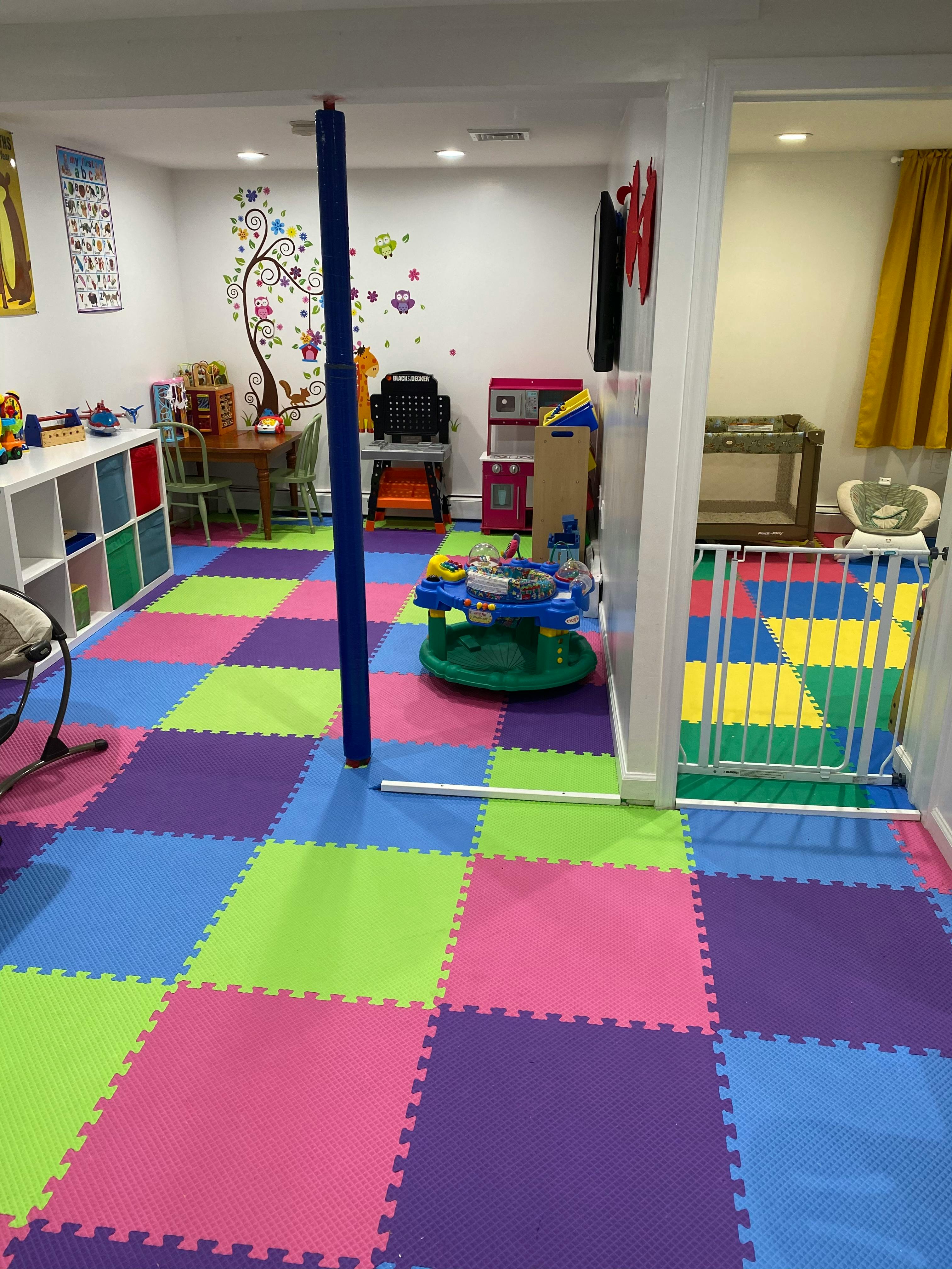 Playroom with colorful foam floor tiles and various toys