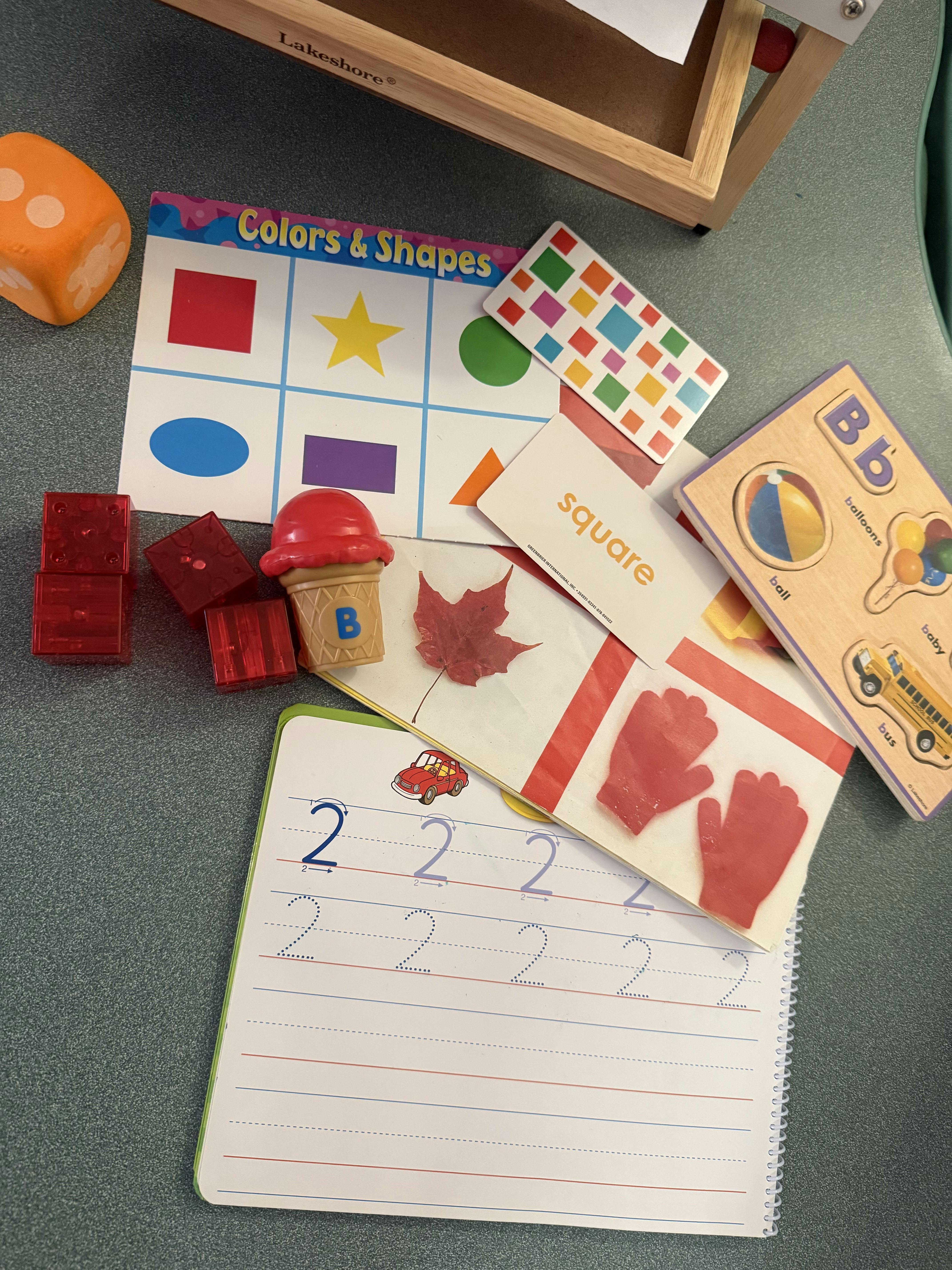 Educational toys and practice sheets for learning shapes letters and numbers