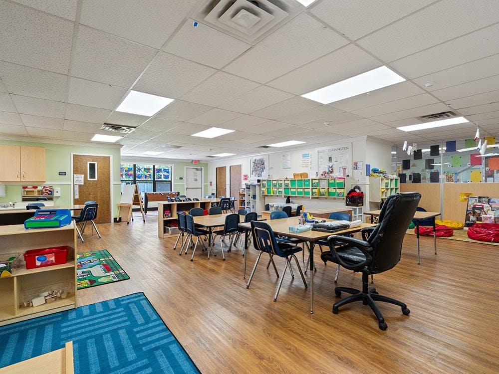 An empty classroom with small tables and chairs