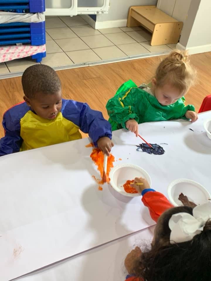 Two children painting at a table