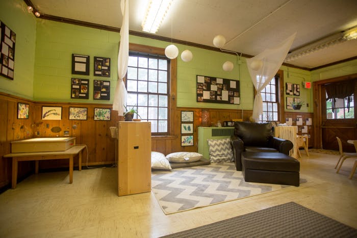 Classroom with green walls, wooden wainscoting, and a black armchair