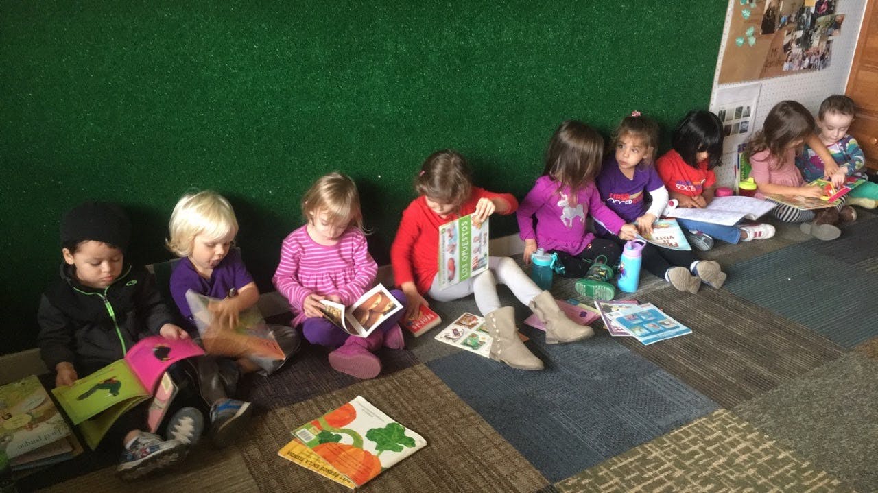 Group of children sitting on floor reading books