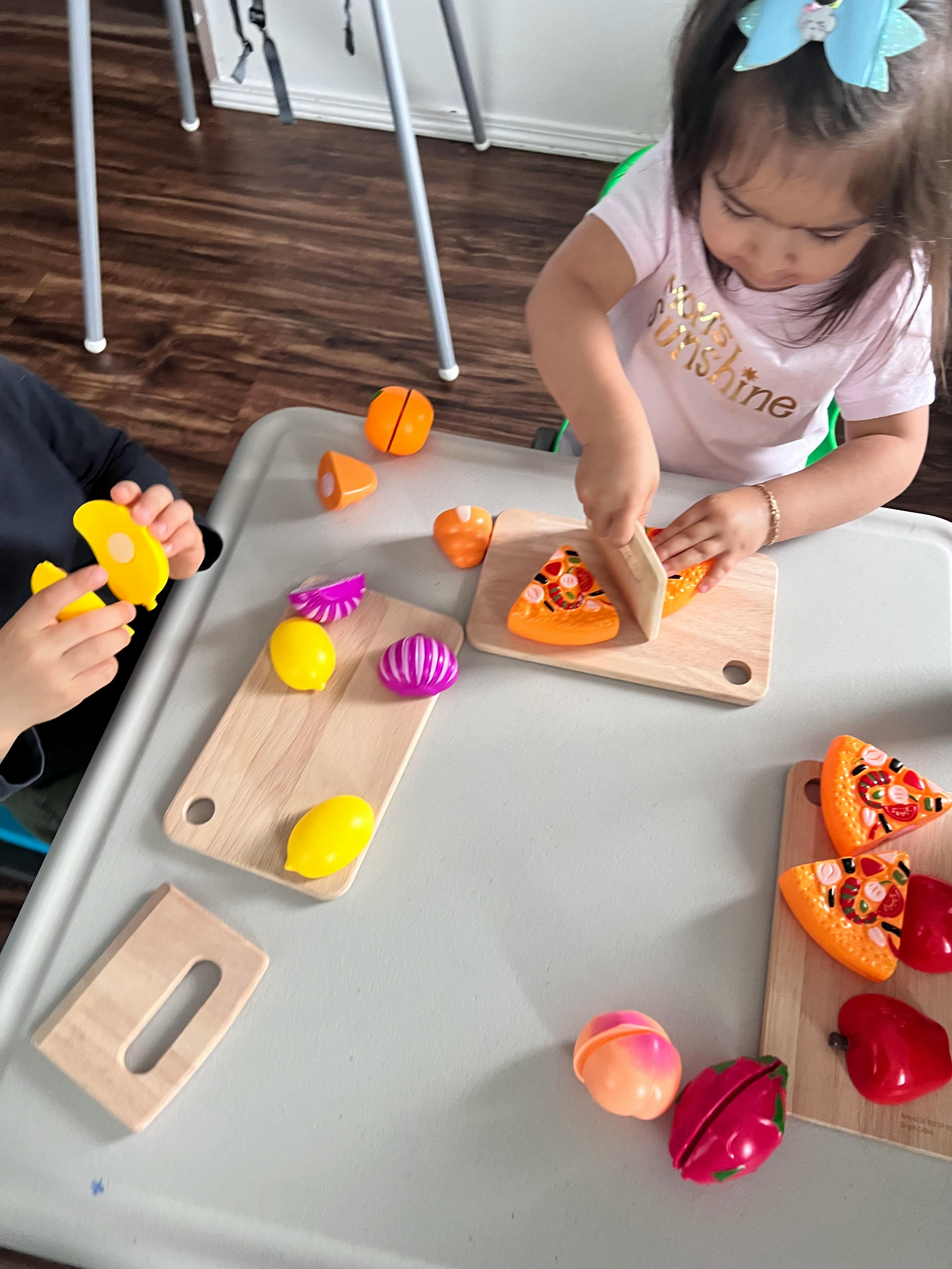 Child playing with toy food on a table