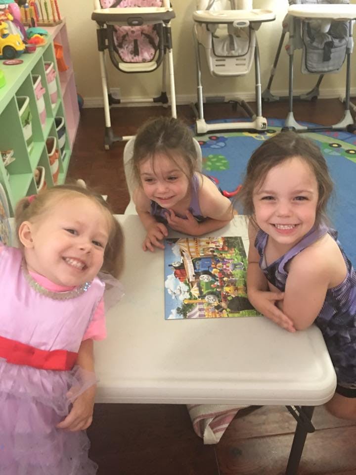 Three children at a table with a puzzle