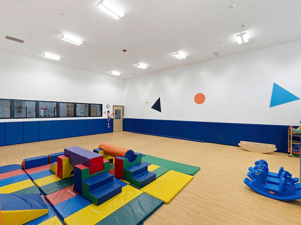 Colorful soft play equipment on mats in an empty playroom