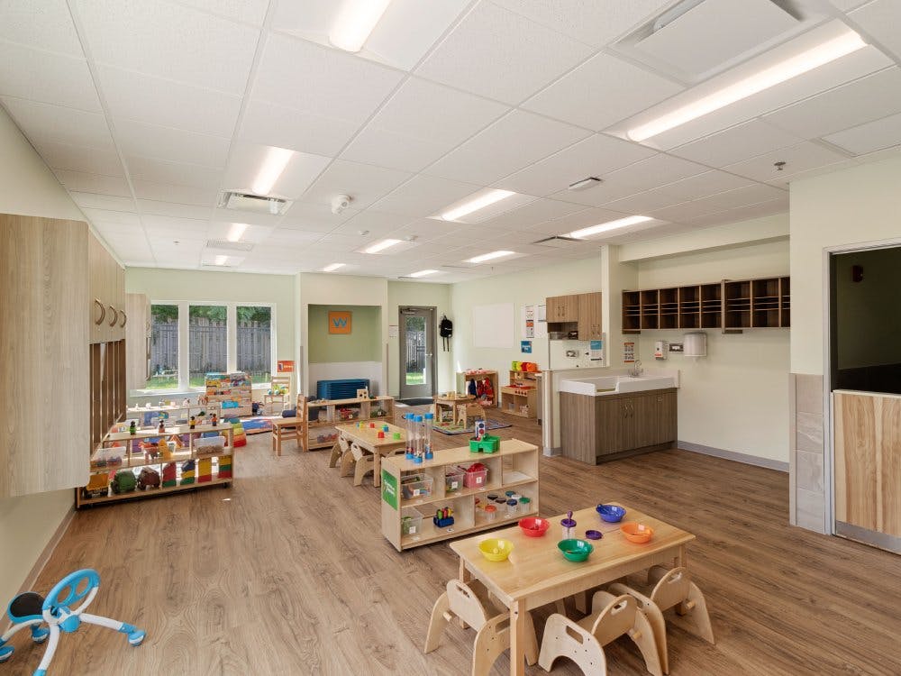 Empty brightly lit classroom with children's furniture and toys