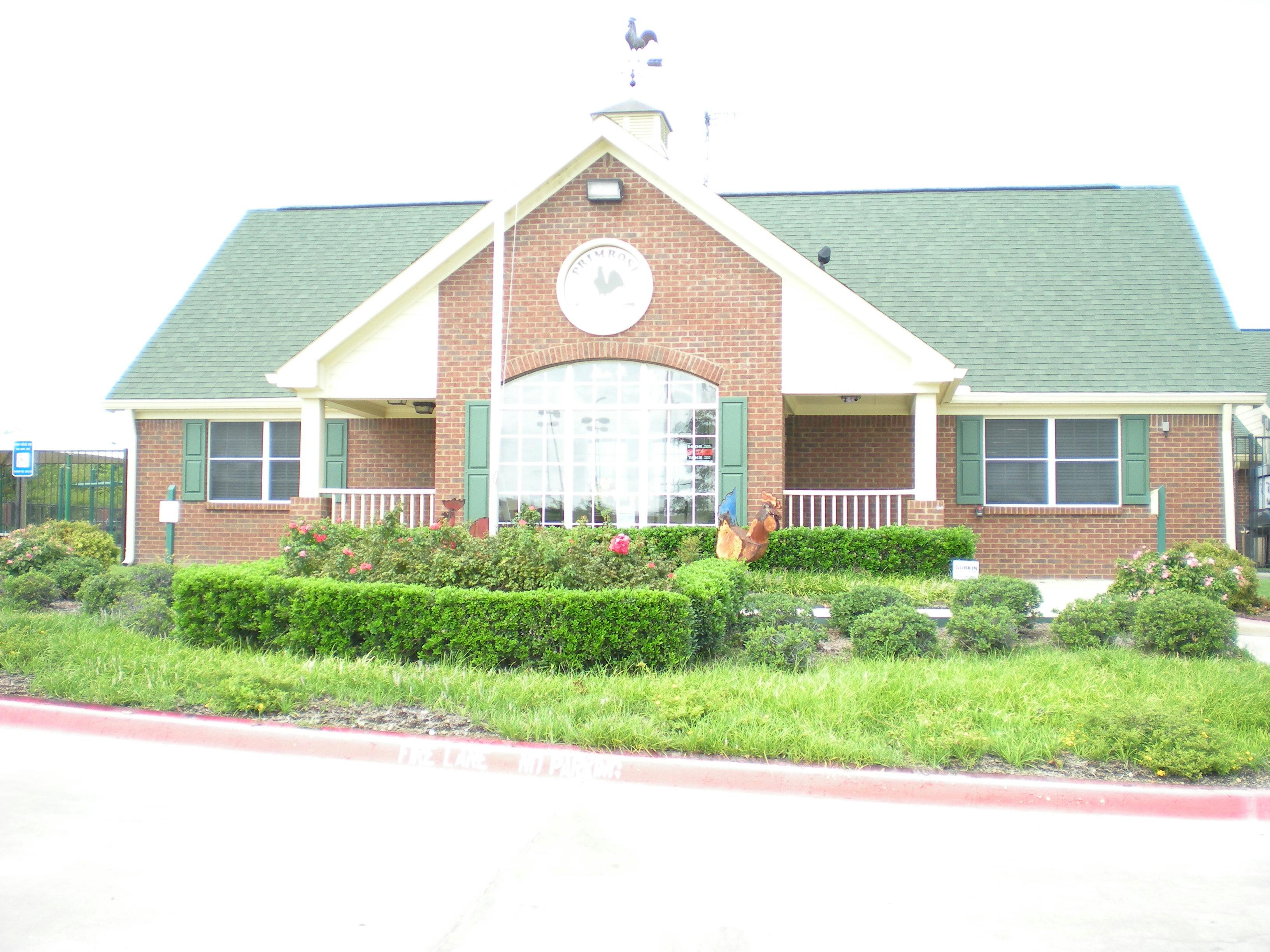 Brick building with green roof and white trim