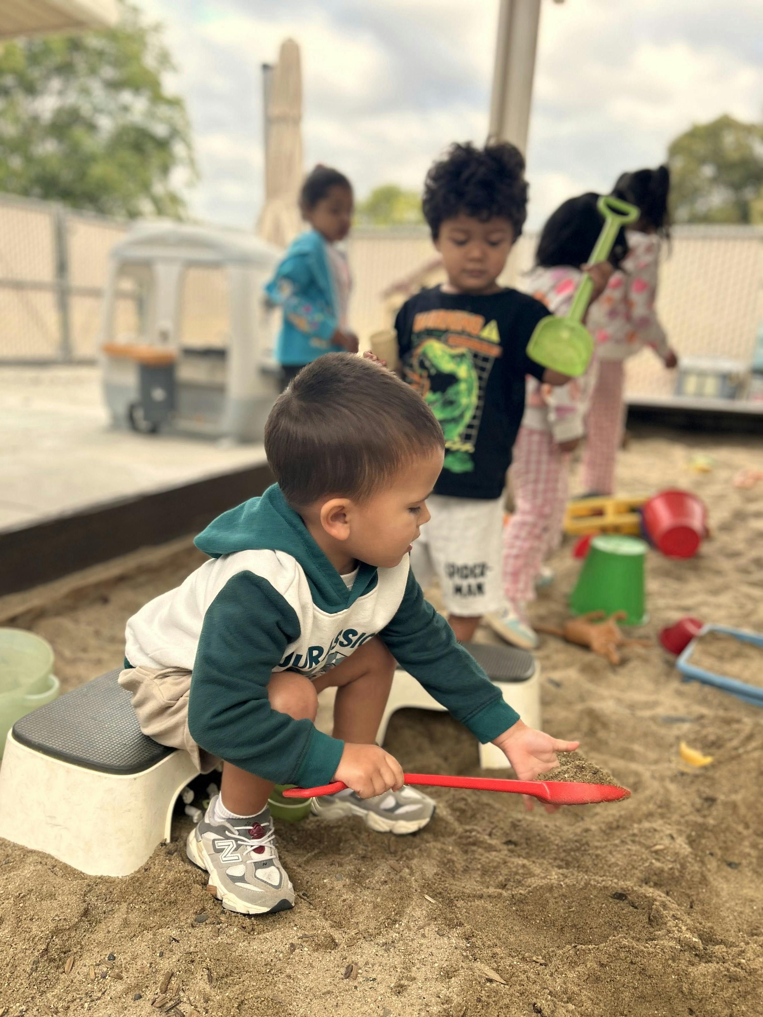 Children playing with shovels in a sandbox