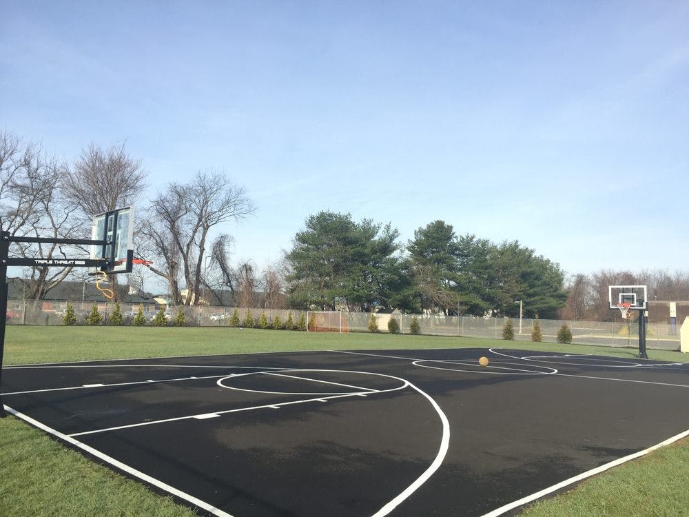 Outdoor basketball court with two hoops and a basketball