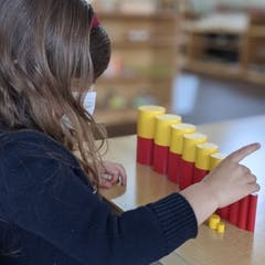 Child playing with red and yellow stacking blocks