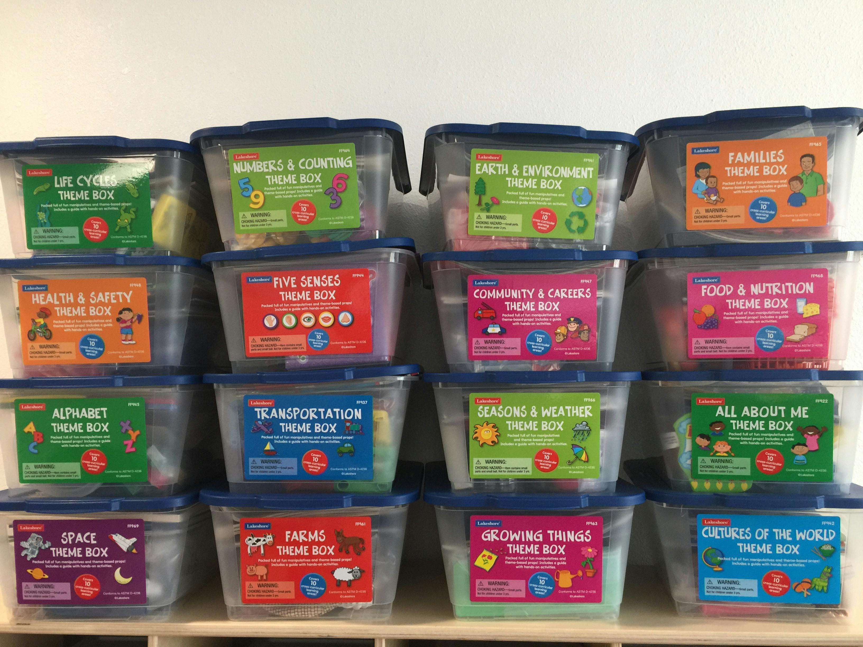 Multiple clear plastic storage bins with colorful labels