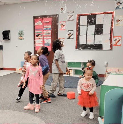 Children standing in a room, some looking up