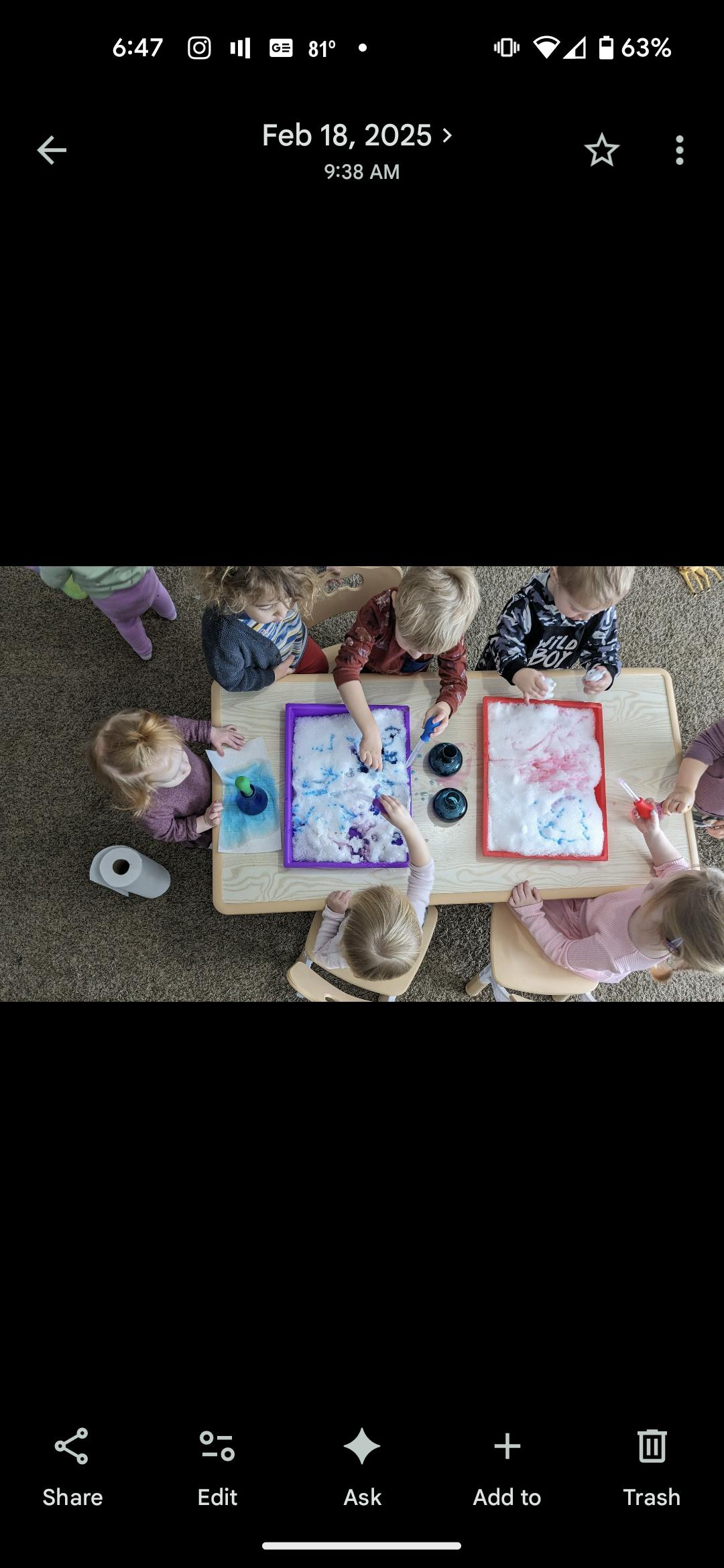 Children at a table playing with colorful foam in plastic trays