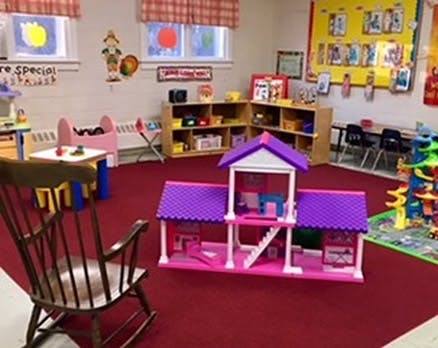 Dollhouse and rocking chair in a classroom