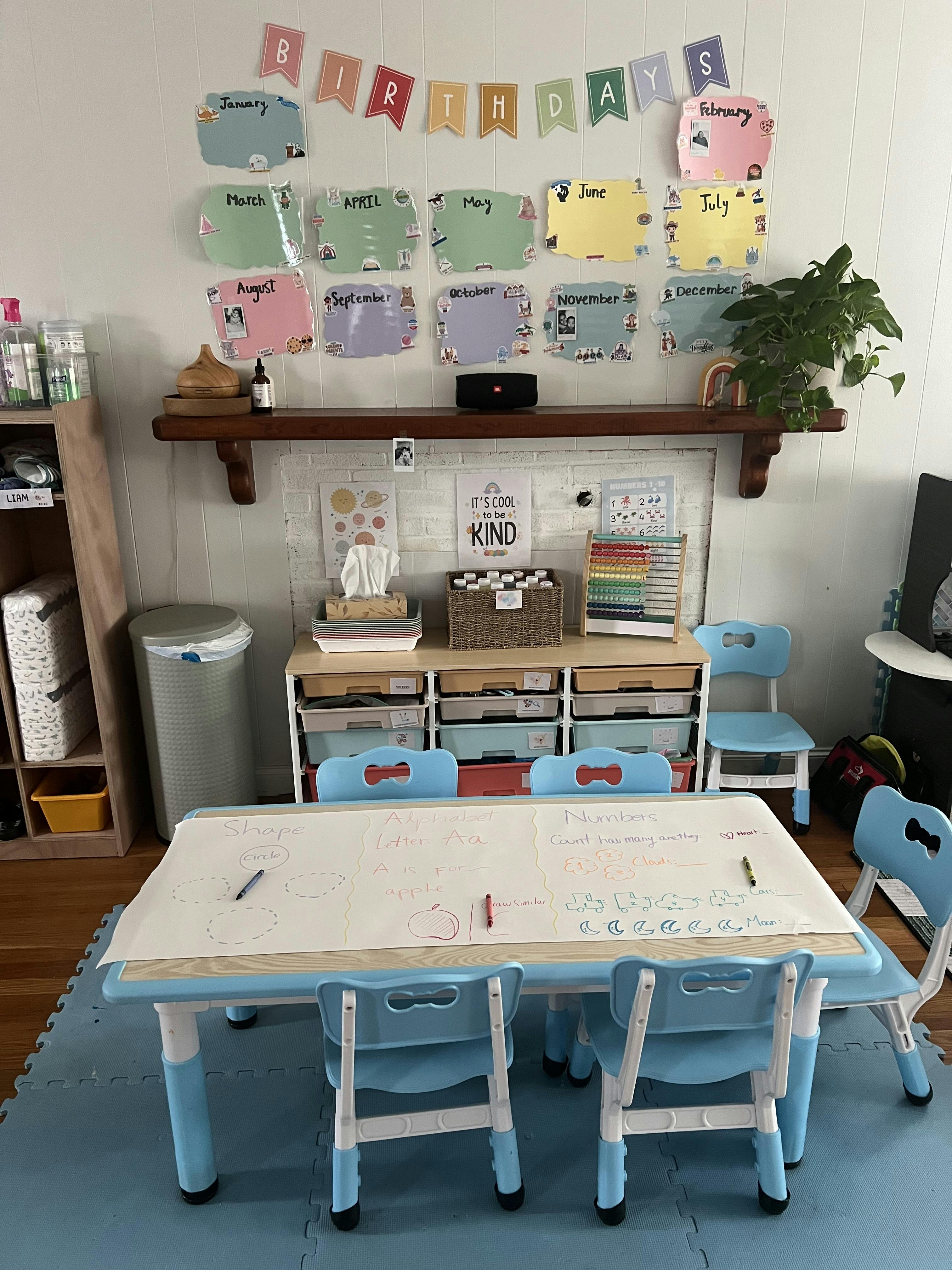 Children's table with chairs, lesson plans, birthday signs, and shelves