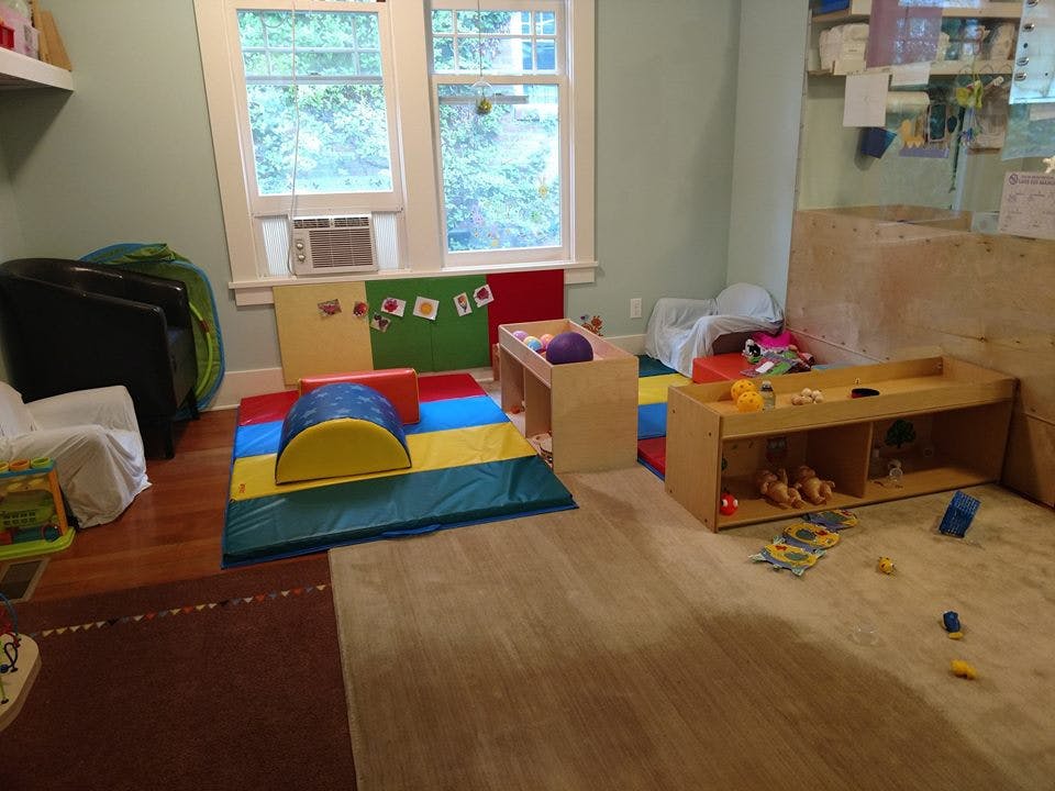 Playroom with soft play equipment, wooden furniture, and toys