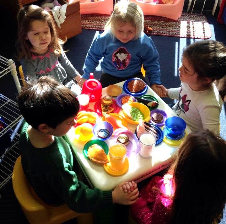 Children playing with toy food at a small table