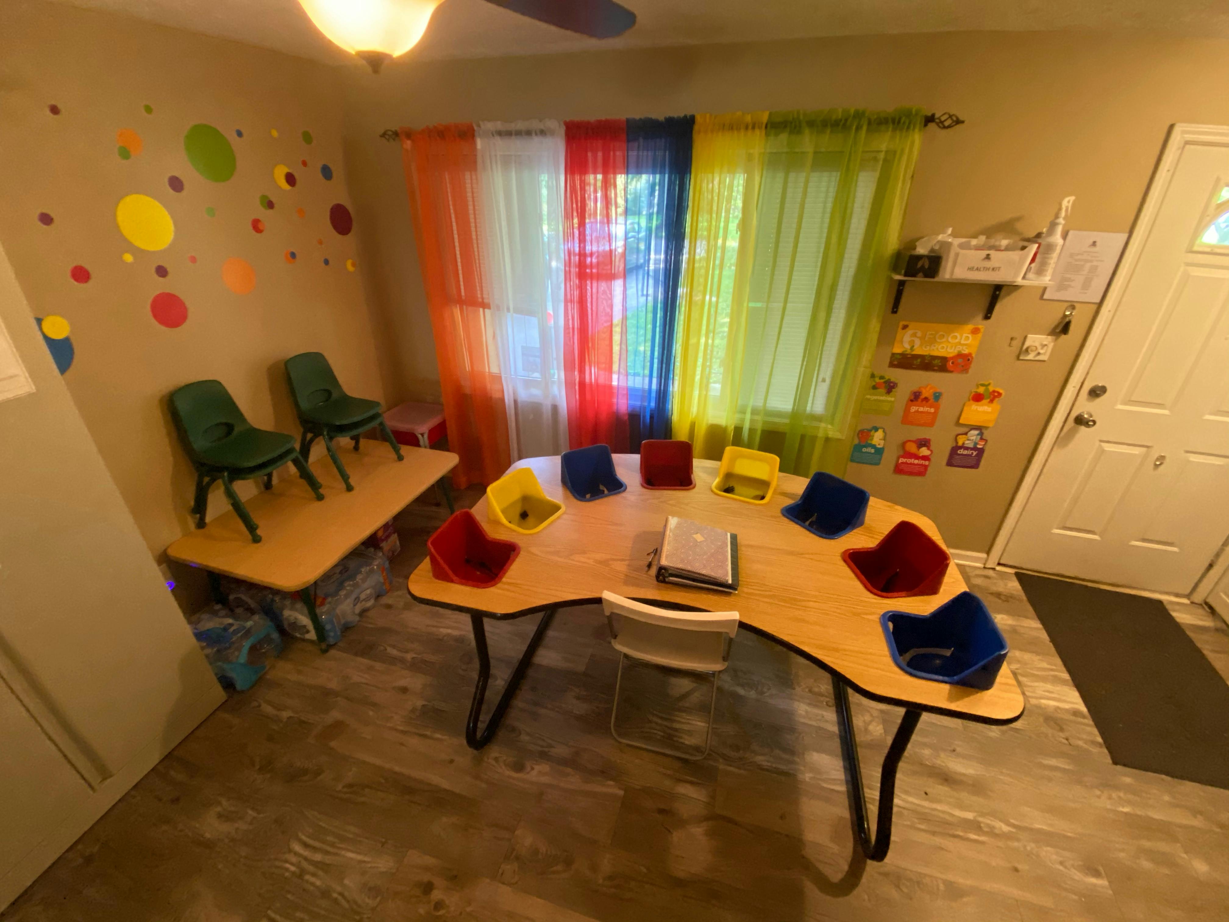 Classroom with a large curved table and smaller rectangular table with chairs