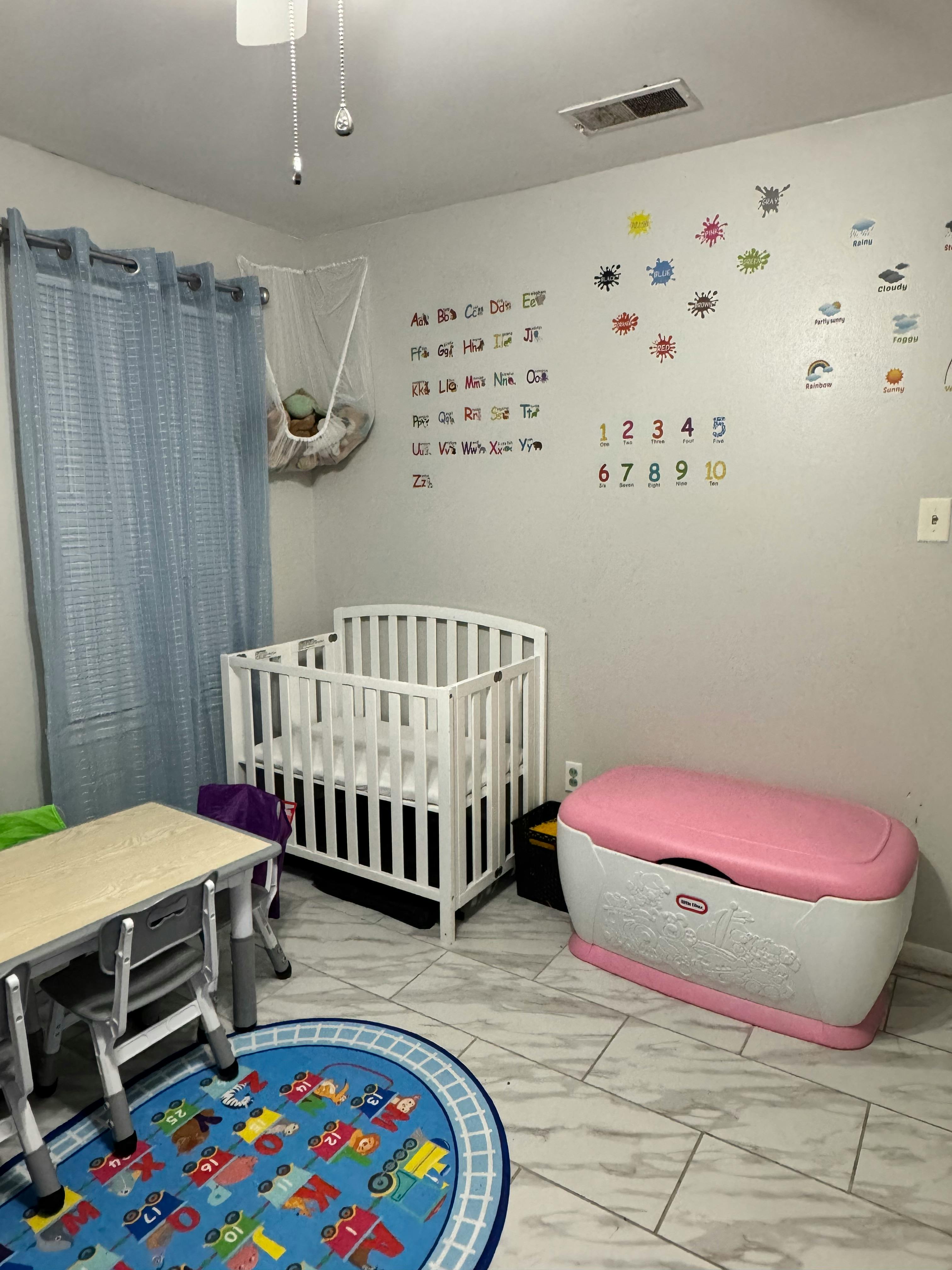 Child's room with a crib, toy chest, and educational wall decals