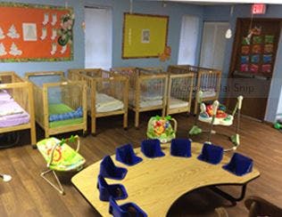 Cribs and small table with chairs in a room