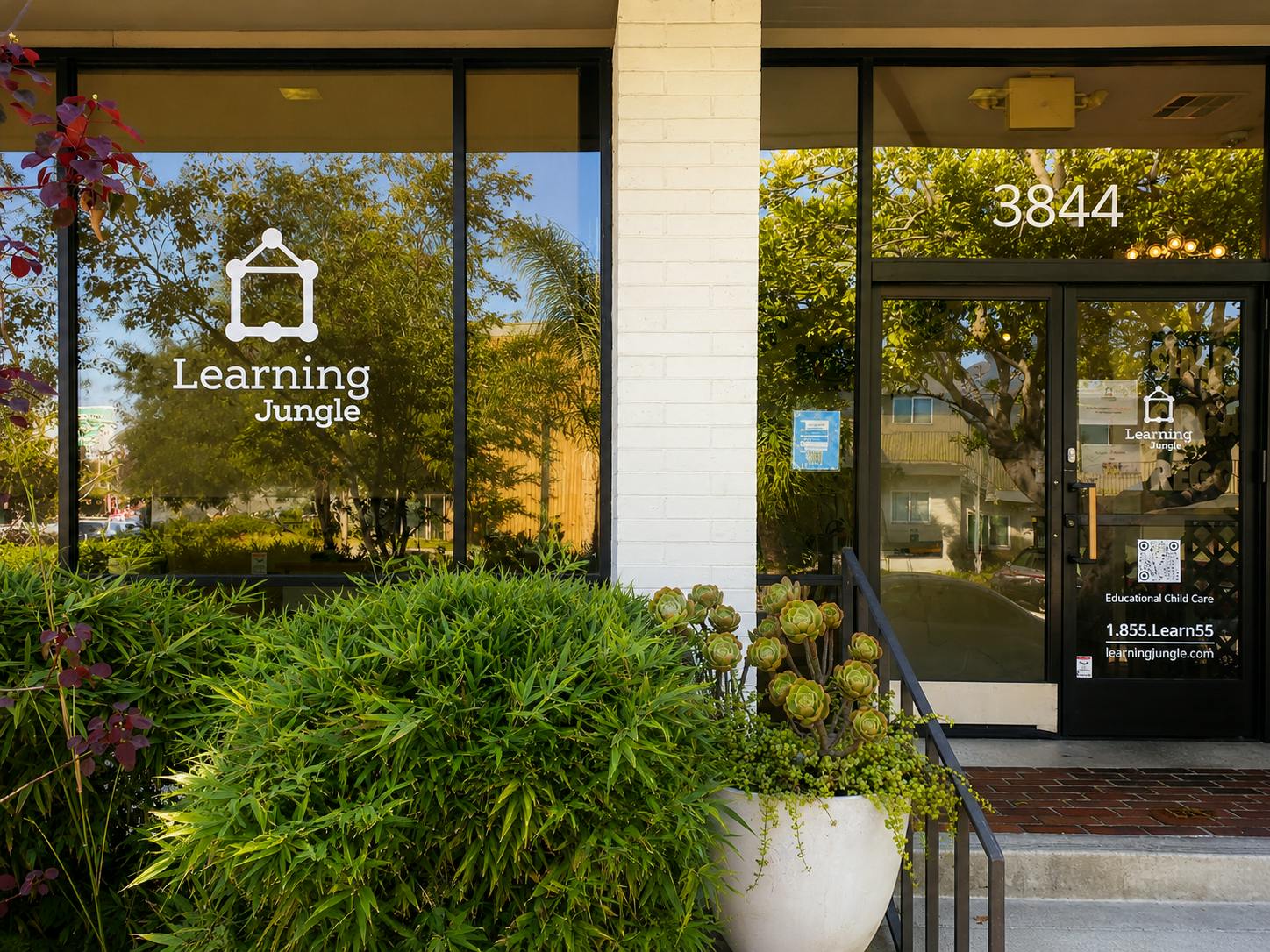 Storefront of a Learning Jungle child care center with glass doors and windows
