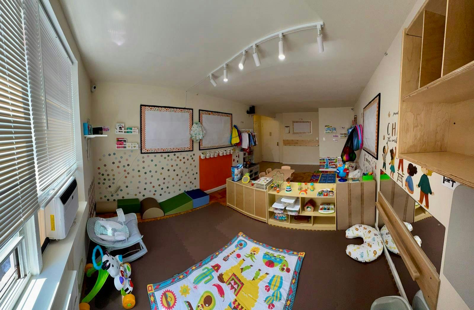 A brightly lit classroom with various learning and play areas