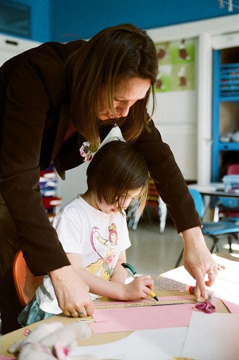Adult and child drawing on paper at a table