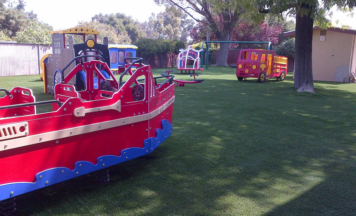 Playground with a red boat, yellow train, and red truck