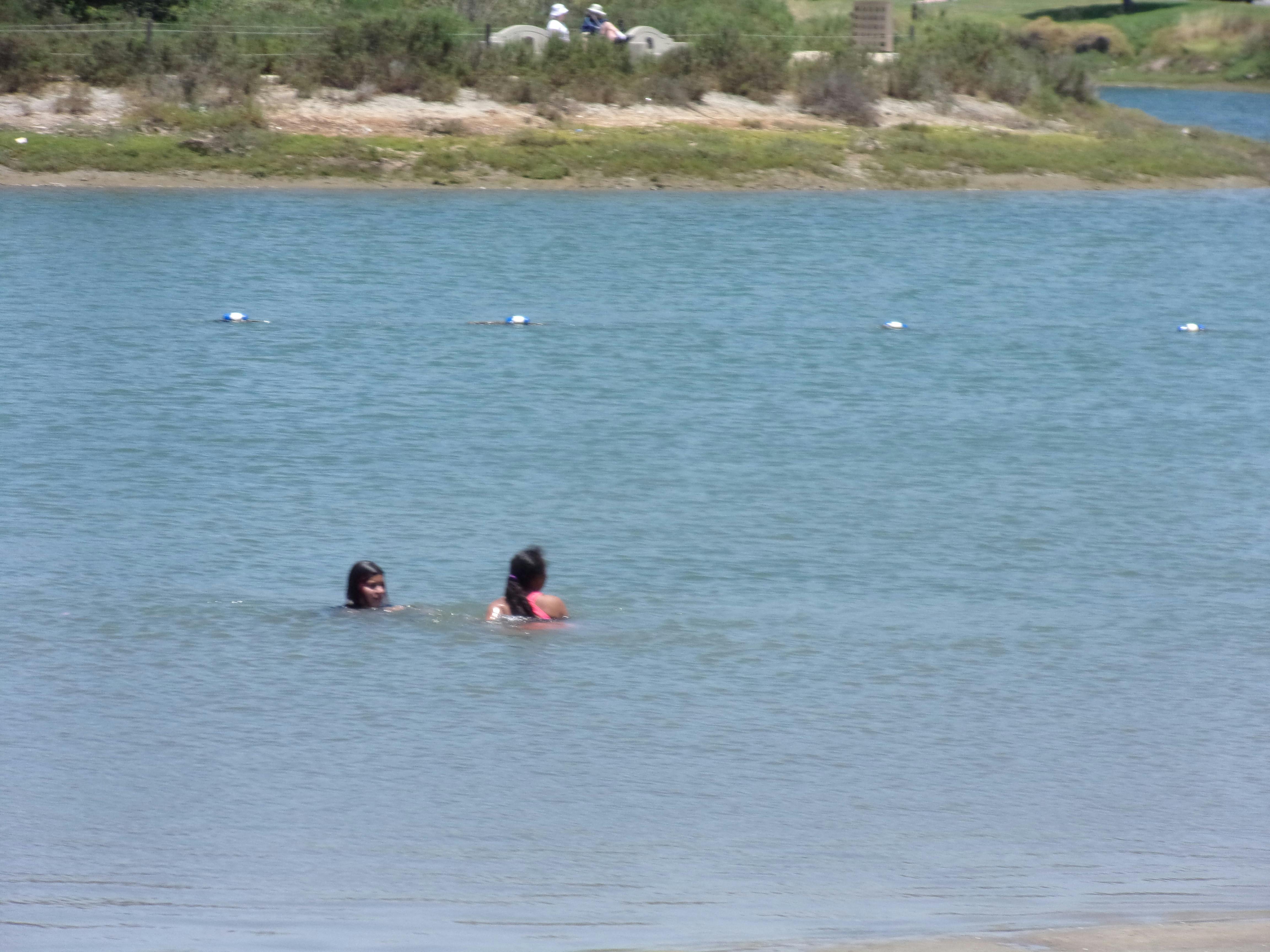 Two people swimming in a lake