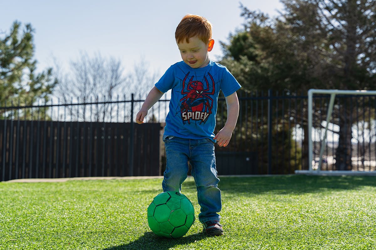 Child playing soccer on a grassy field