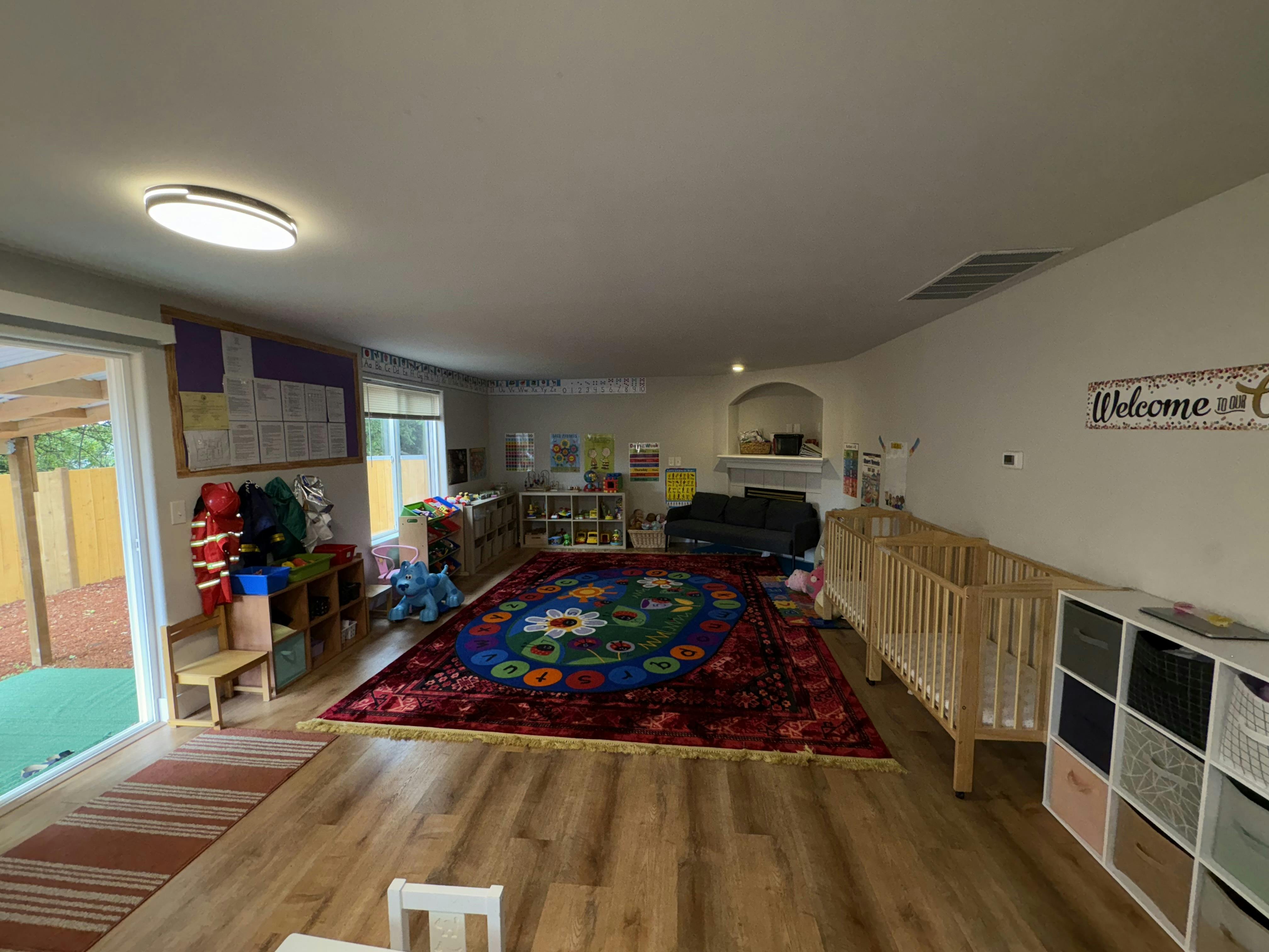 Playroom with a colorful rug, crib, and toys