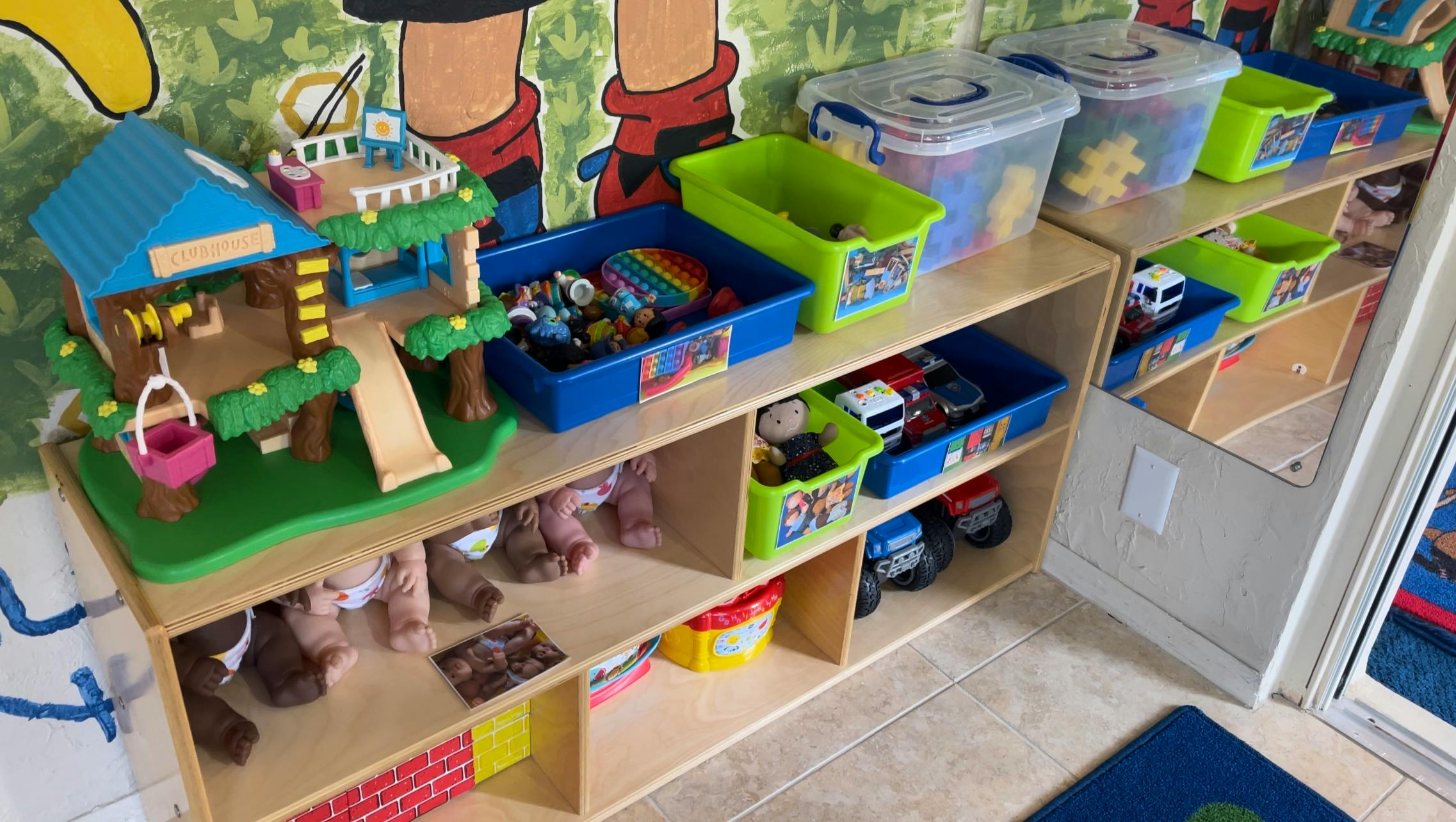 Shelves with toys, including a dollhouse, bins, and stuffed animals