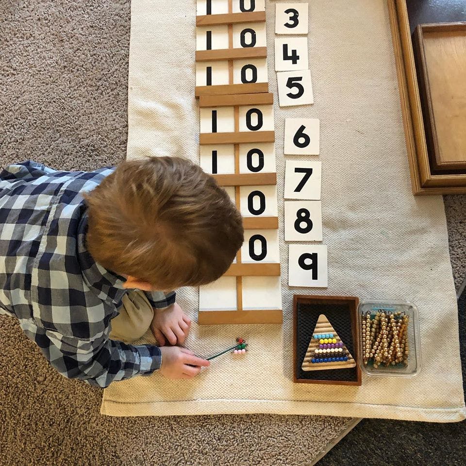 Child playing with number blocks and counting materials on a mat