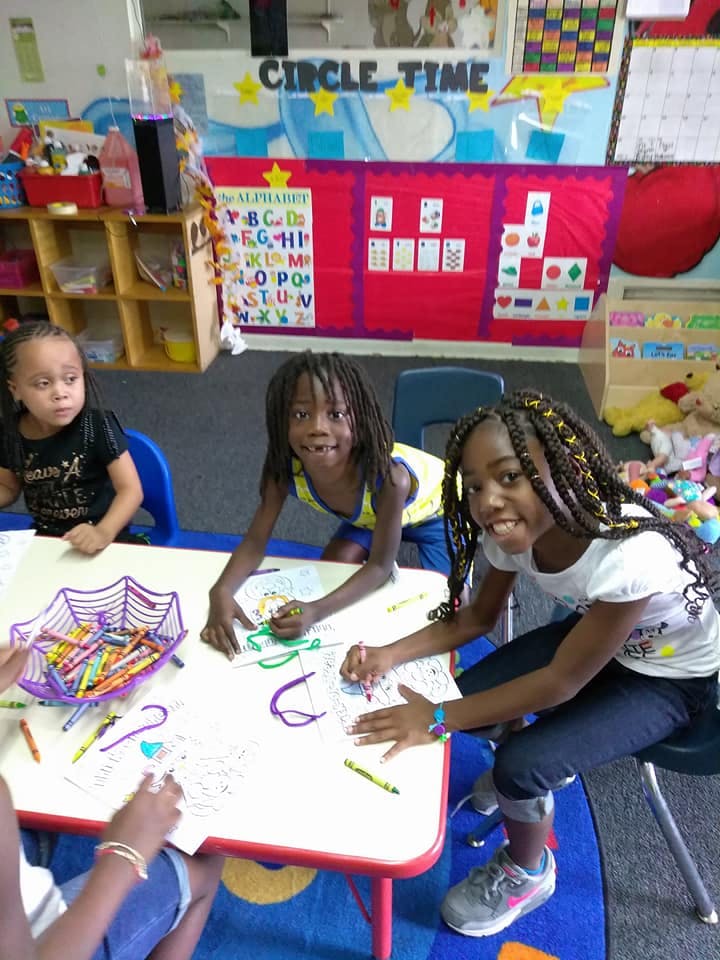 Children drawing at a table in a classroom