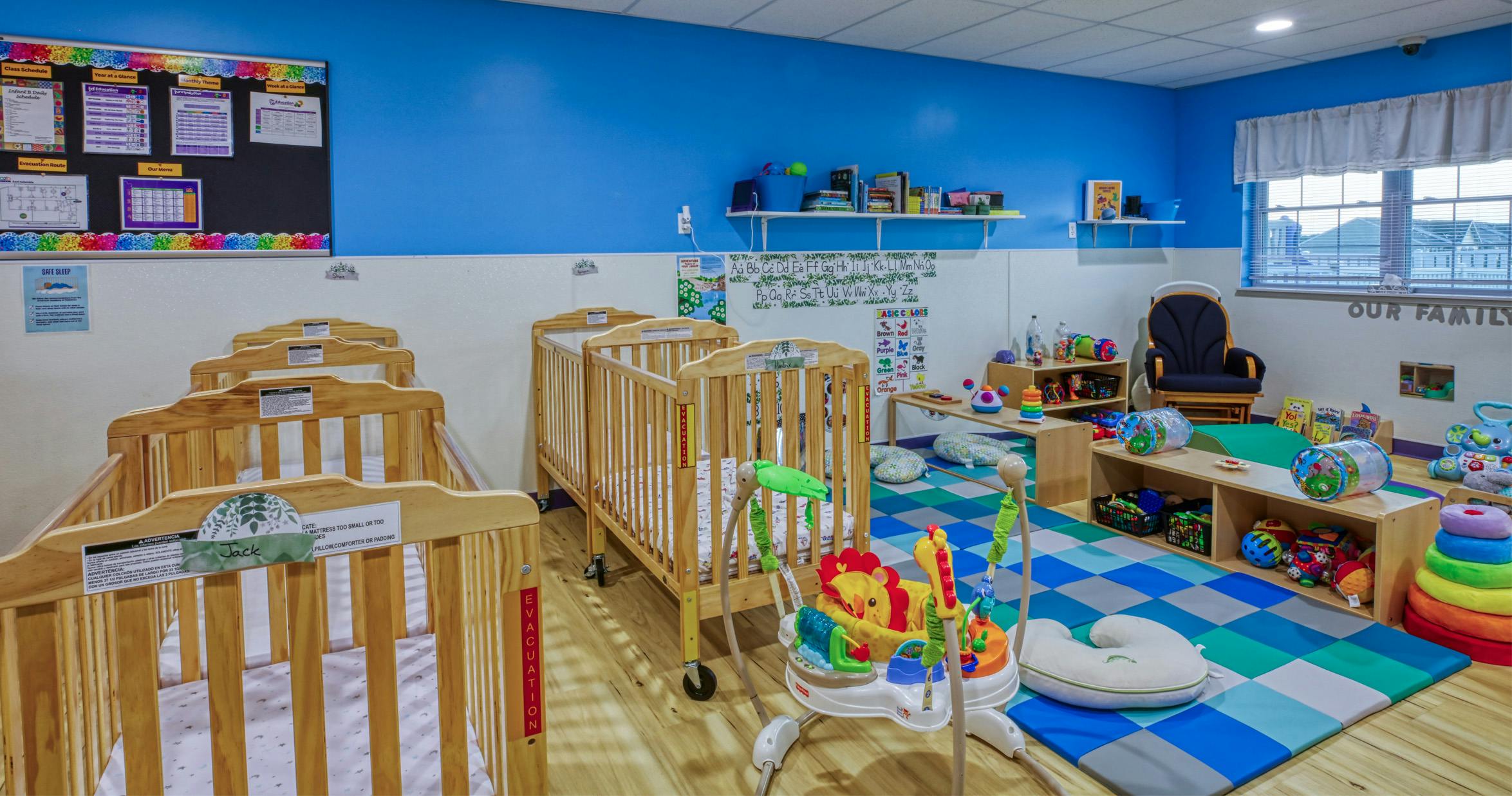 Baby room with several cribs, play mats, and learning toys