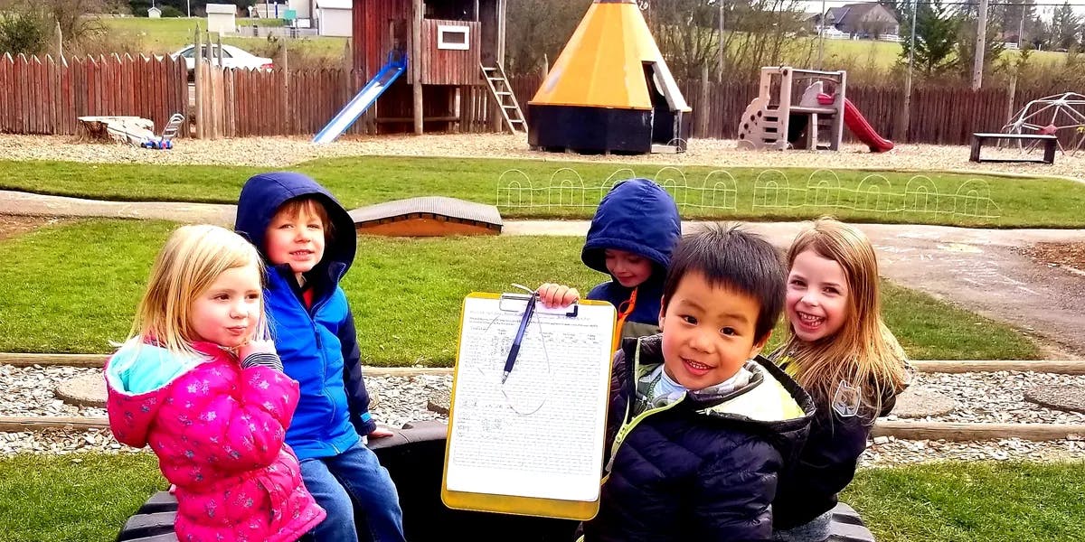Children holding a clipboard on a playground