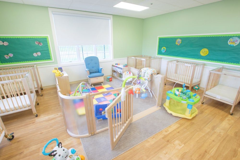 Nursery room with multiple cribs, playpen, and toys